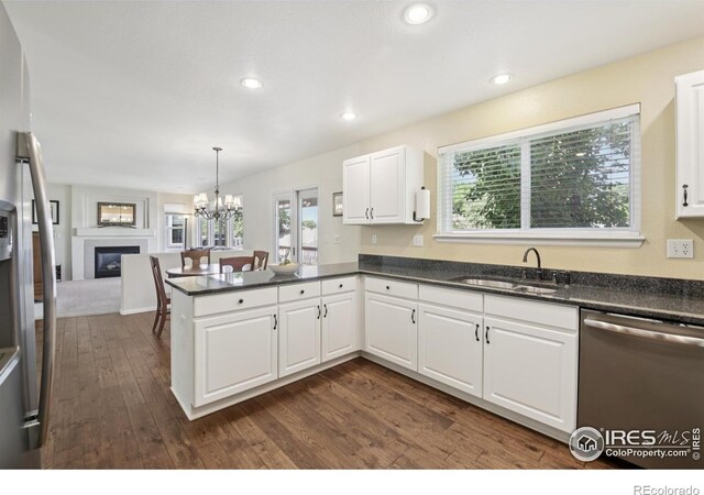 2608 E 132nd Ave, Thornton, CO 80241 - kitchen with stainless steel dishwasher, a chandelier, dark wood-type flooring, open floor plan, and a peninsula