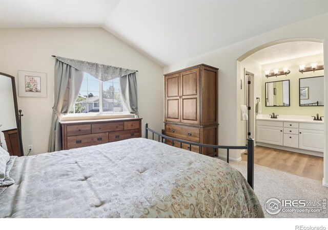 2608 E 132nd Ave, Thornton, CO 80241 - bedroom featuring vaulted ceiling, light carpet, arched walkways, and ensuite bathroom