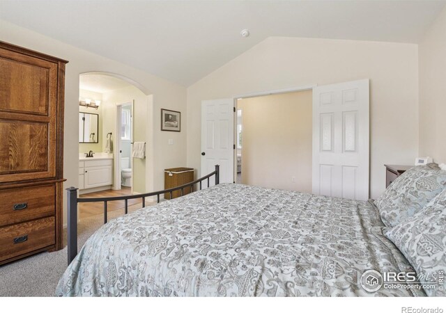 2608 E 132nd Ave, Thornton, CO 80241 - carpeted bedroom featuring lofted ceiling, arched walkways, and ensuite bathroom