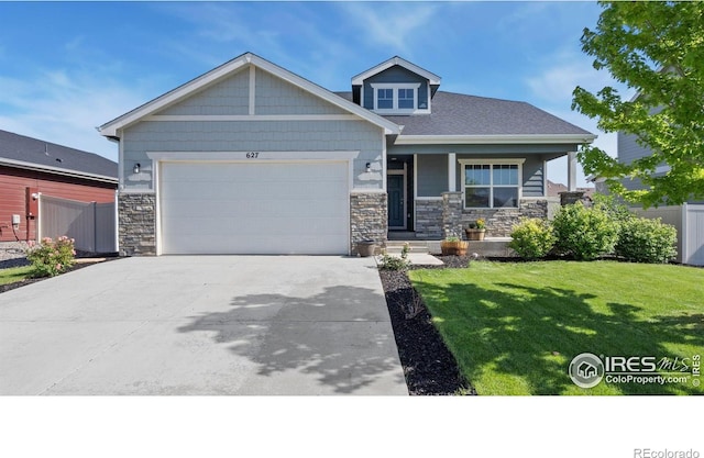 627 Overland Trl, Ault, CO 80610 - craftsman inspired home featuring stone siding, concrete driveway, an attached garage, and covered porch