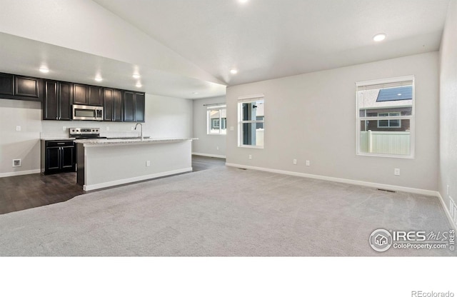627 Overland Trl, Ault, CO 80610 - kitchen with stainless steel appliances, carpet floors, open floor plan, lofted ceiling, and recessed lighting