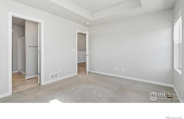 627 Overland Trl, Ault, CO 80610 - unfurnished bedroom featuring a spacious closet, carpet, and a raised ceiling