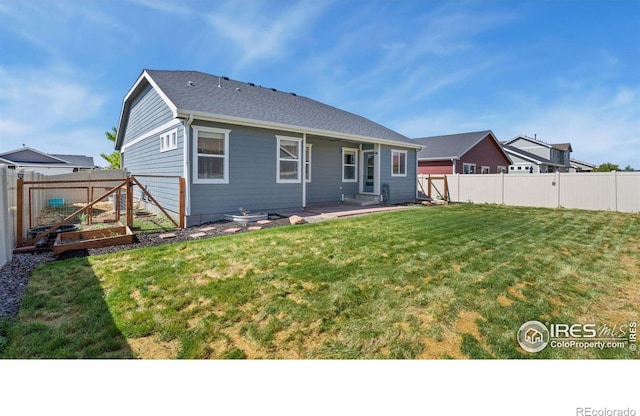 627 Overland Trl, Ault, CO 80610 - back of property featuring a garden, a fenced backyard, and a patio area