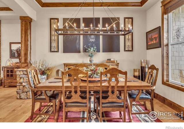 37021 Kingfisher Ct, Severance, CO 80550 - dining area with a chandelier, wood finished floors, and ornate columns