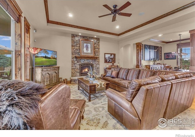 37021 Kingfisher Ct, Severance, CO 80550 - living area featuring a raised ceiling, ceiling fan, a stone fireplace, crown molding, and recessed lighting