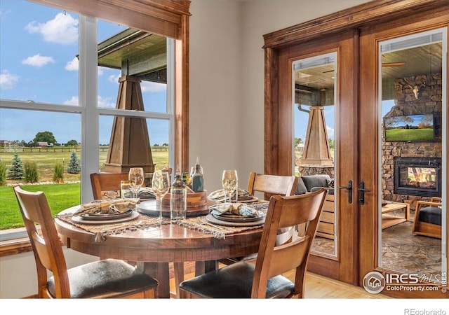 37021 Kingfisher Ct, Severance, CO 80550 - dining space with plenty of natural light, a fireplace, and french doors