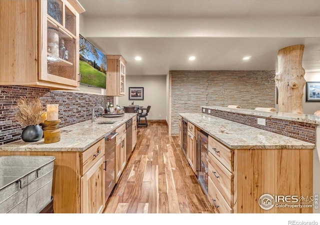37021 Kingfisher Ct, Severance, CO 80550 - kitchen featuring light wood-type flooring, light brown cabinets, decorative backsplash, glass insert cabinets, and light stone countertops