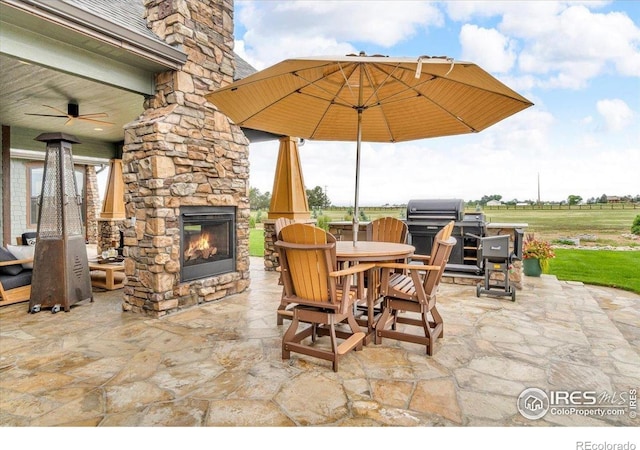 37021 Kingfisher Ct, Severance, CO 80550 - view of patio with an outdoor stone fireplace, a grill, outdoor dining area, and ceiling fan