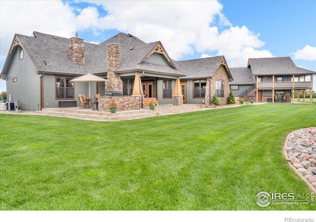 37021 Kingfisher Ct, Severance, CO 80550 - rear view of property with a chimney, a lawn, a patio, and a shingled roof