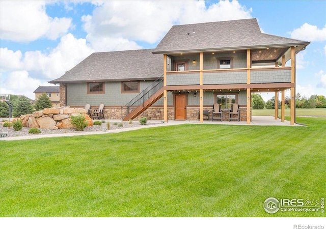 37021 Kingfisher Ct, Severance, CO 80550 - back of property featuring a patio area, a lawn, stairway, and a shingled roof