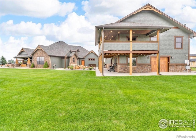 37021 Kingfisher Ct, Severance, CO 80550 - rear view of property with a patio area, a lawn, stone siding, and a sunroom