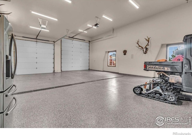 37021 Kingfisher Ct, Severance, CO 80550 - garage with a garage door opener and stainless steel fridge with ice dispenser