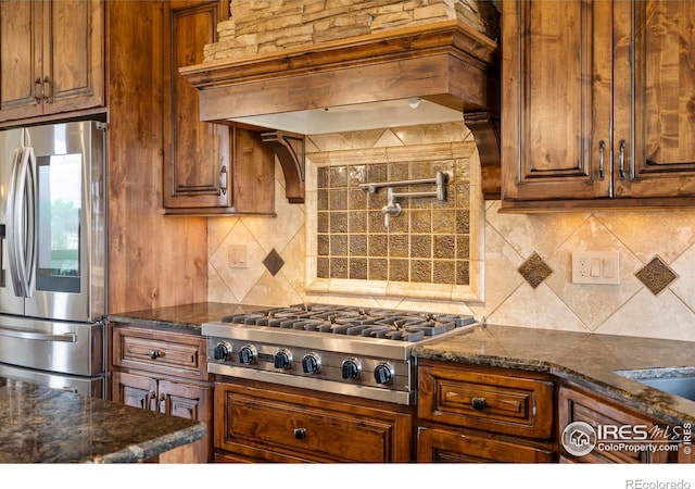 863 Riparian Way, Fort Collins, CO 80524 - kitchen featuring stainless steel appliances, premium range hood, tasteful backsplash, and dark stone countertops