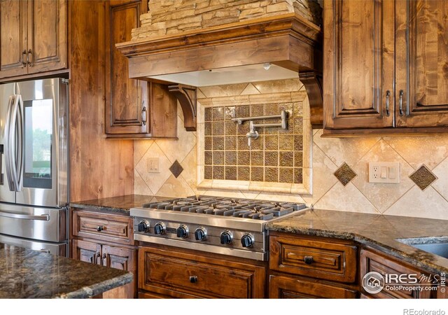 863 Riparian Way, Fort Collins, CO 80524 - kitchen with stainless steel appliances, custom exhaust hood, decorative backsplash, and dark stone counters