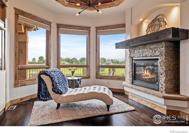 863 Riparian Way, Fort Collins, CO 80524 - sitting room with a stone fireplace, dark wood-style flooring, a chandelier, and a tray ceiling