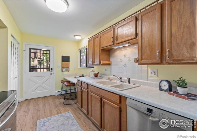 705 E Drake Rd Unit 40, Fort Collins, CO 80525 - kitchen with stainless steel appliances, a baseboard radiator, light wood finished floors, light countertops, and brown cabinetry