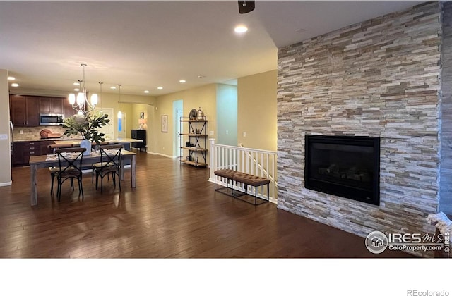 306 Baja Dr, Windsor, CO 80550 - dining room with dark wood-style flooring, a fireplace, recessed lighting, and a chandelier