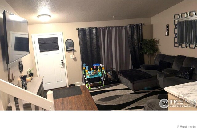 3200 Claremont Ave, Evans, CO 80620 - living area featuring wood finished floors and a textured ceiling