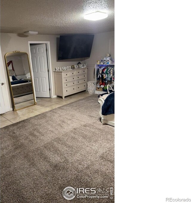 3200 Claremont Ave, Evans, CO 80620 - tiled bedroom featuring a textured ceiling and carpet floors