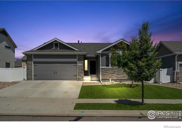 452 Mt Sherman Ave, Severance, CO 80550 - view of front of home featuring stone siding, driveway, an attached garage, and roof with shingles