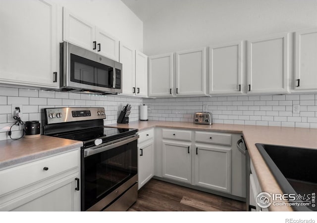 452 Mt Sherman Ave, Severance, CO 80550 - kitchen featuring appliances with stainless steel finishes, light countertops, white cabinets, decorative backsplash, and dark wood-type flooring