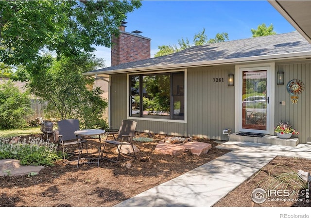 7261 Mount Meeker Rd, Longmont, CO 80503 - doorway to property with a chimney and roof with shingles