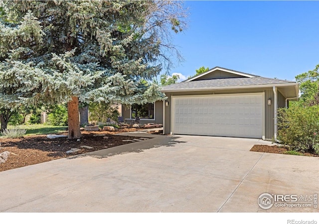 7261 Mount Meeker Rd, Longmont, CO 80503 - view of front of house with concrete driveway, an attached garage, and roof with shingles