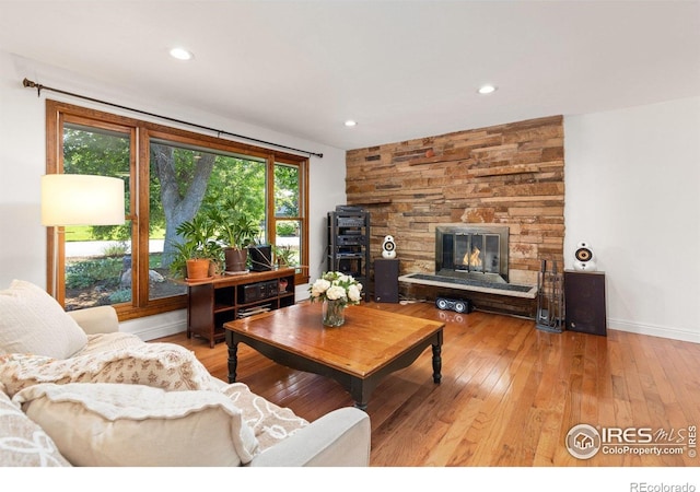 7261 Mount Meeker Rd, Longmont, CO 80503 - living area with light wood-type flooring, a stone fireplace, and recessed lighting