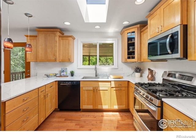 7261 Mount Meeker Rd, Longmont, CO 80503 - kitchen featuring appliances with stainless steel finishes, a peninsula, light wood finished floors, light stone counters, and recessed lighting