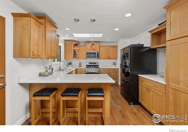 7261 Mount Meeker Rd, Longmont, CO 80503 - kitchen featuring stainless steel appliances, a skylight, open shelves, a peninsula, and light wood finished floors