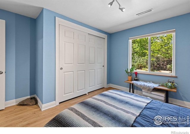 7261 Mount Meeker Rd, Longmont, CO 80503 - bedroom with wood finished floors, a closet, and rail lighting