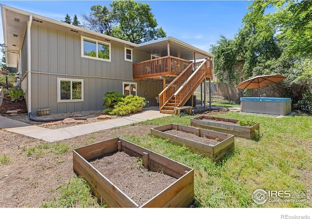 7261 Mount Meeker Rd, Longmont, CO 80503 - rear view of house featuring a hot tub, a vegetable garden, a deck, and stairs