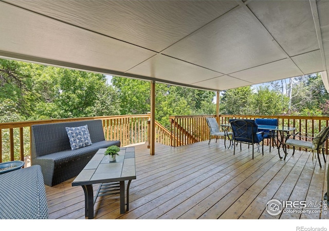 7261 Mount Meeker Rd, Longmont, CO 80503 - wooden deck featuring outdoor lounge area, outdoor dining space, and view of wooded area