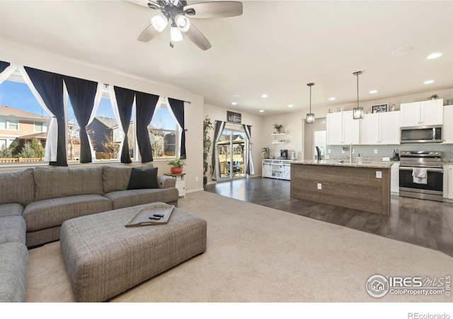 6504 Zimmerman Lake Rd, Timnath, CO 80547 - living area with dark colored carpet, recessed lighting, a ceiling fan, and dark wood-type flooring