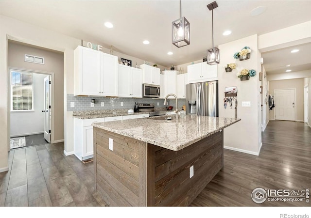6504 Zimmerman Lake Rd, Timnath, CO 80547 - kitchen with appliances with stainless steel finishes, backsplash, dark wood-type flooring, white cabinetry, and recessed lighting