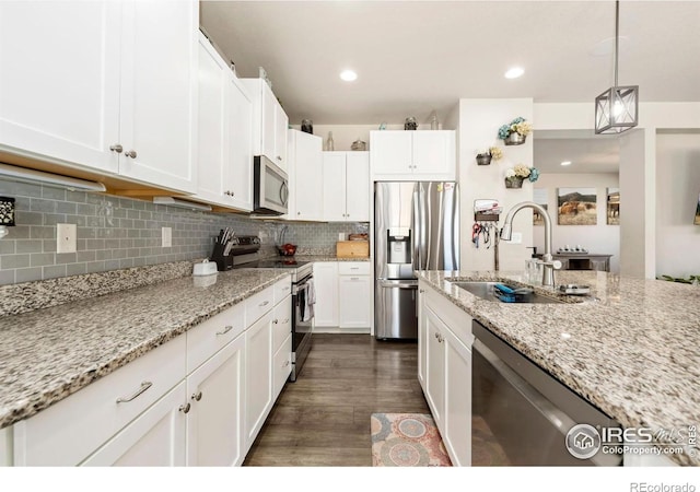 6504 Zimmerman Lake Rd, Timnath, CO 80547 - kitchen with appliances with stainless steel finishes, white cabinets, light stone counters, tasteful backsplash, and recessed lighting