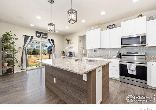 6504 Zimmerman Lake Rd, Timnath, CO 80547 - kitchen with stainless steel appliances, light wood-style flooring, tasteful backsplash, recessed lighting, and white cabinetry