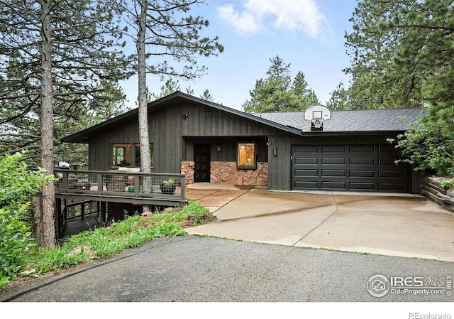 2433 Linden Dr, Boulder, CO 80304 - mid-century modern home featuring a garage, driveway, stone siding, and roof with shingles