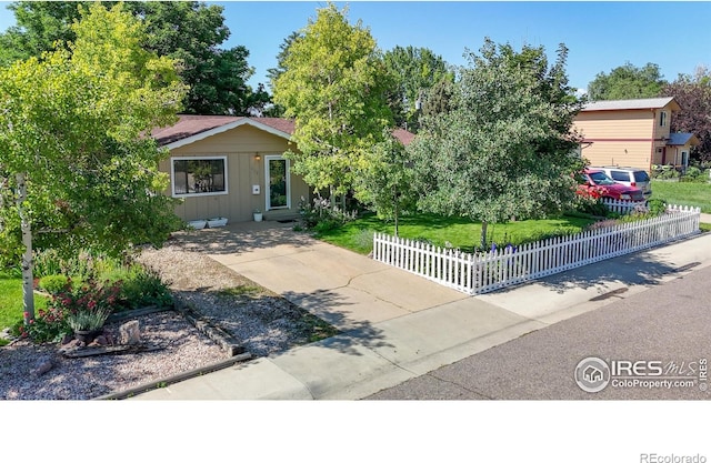 1112 E 16th St, Loveland, CO 80538 - view of property hidden behind natural elements featuring a fenced front yard and board and batten siding