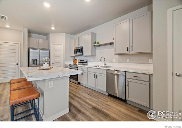 620 Apache Trl Unit 2, Ault, CO 80610 - kitchen featuring stainless steel appliances, open shelves, a kitchen bar, gray cabinetry, and a center island