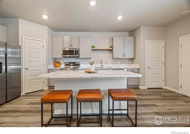 620 Apache Trl Unit 2, Ault, CO 80610 - kitchen featuring appliances with stainless steel finishes, a kitchen bar, dark wood-type flooring, a kitchen island, and recessed lighting