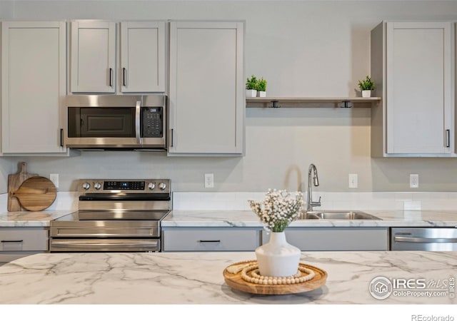 620 Apache Trl Unit 2, Ault, CO 80610 - kitchen featuring appliances with stainless steel finishes, open shelves, and light stone countertops