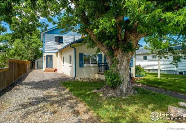 403 W Cannon St, Lafayette, CO 80026 - rear view of house with stucco siding, gravel driveway, and an outdoor structure