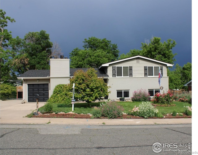 6864 Balsam St, Arvada, CO 80004 - split level home with driveway, a garage, a chimney, and a front yard