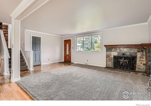 6864 Balsam St, Arvada, CO 80004 - unfurnished living room with stairway, ornamental molding, a tiled fireplace, and wood finished floors