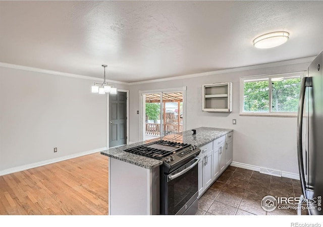 6864 Balsam St, Arvada, CO 80004 - kitchen with appliances with stainless steel finishes, a peninsula, light stone counters, crown molding, and healthy amount of natural light