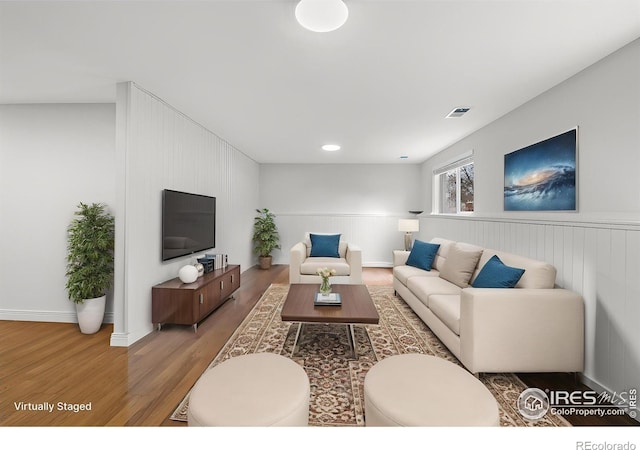 6864 Balsam St, Arvada, CO 80004 - living area featuring wood finished floors and a wainscoted wall