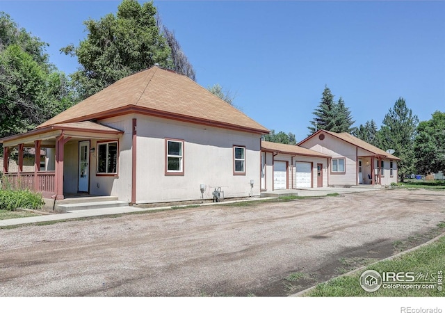 1343 E 7th St Unit 1, Loveland, CO 80537 - view of front of property with covered porch, a garage, and driveway