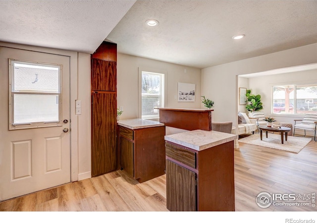 1343 E 7th St Unit 1, Loveland, CO 80537 - kitchen with light wood-type flooring, a textured ceiling, light countertops, brown cabinetry, and recessed lighting