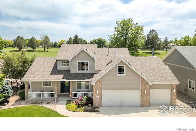 5072 Saint Andrews Dr, Loveland, CO 80537 - view of front of home featuring a porch, brick siding, a garage, a shingled roof, and driveway